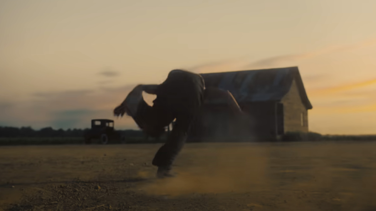 Jack O'Connell as Remmick stumbling in the dirt in Sinners