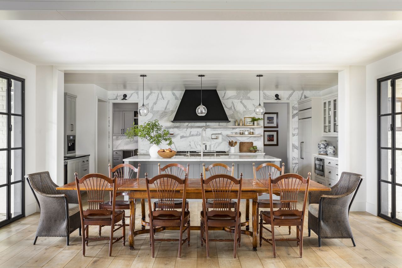 Kitchen with wood table and chairs, gray island and cabinets and wood floor