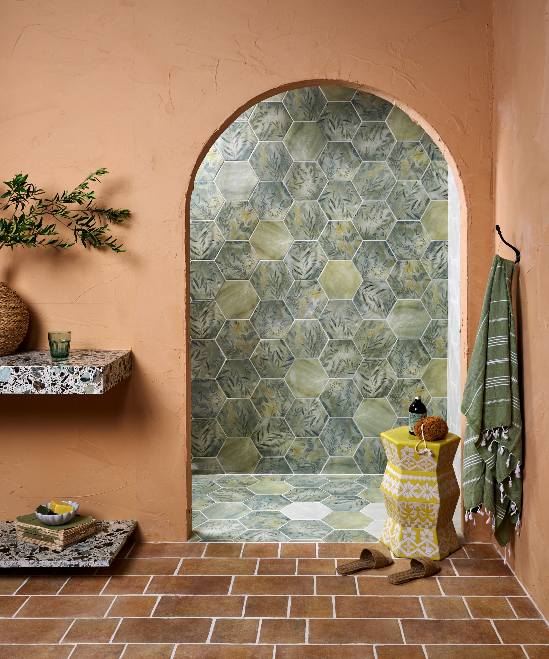 A pink and green bathroom with an archway leading into the shower.