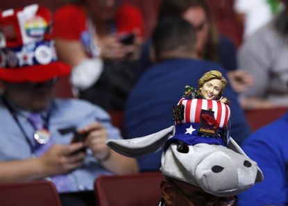 A delegate with a hat incorporating the Democratic donkey mascot and a figurine of Democratic U.S. presdential candidate Hillary Clinton.