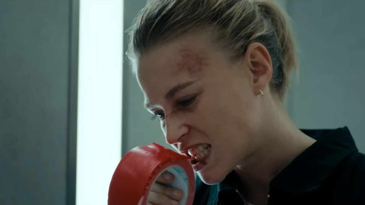 Jeanne Goursaud chewing on tape in Exterritorial.