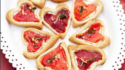 Tarts cut into heart shapes with tomato and pepper
