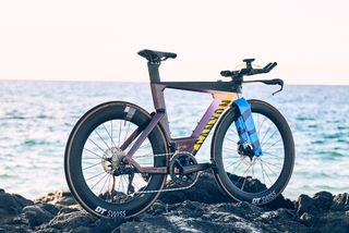 A Canyon Speedmax CF SLX Hawaii LTD sits on some rocks in front of the sea