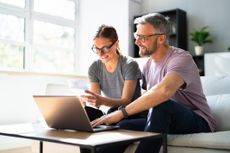 A middle-aged couple sits together going over a retirement planning checklist.