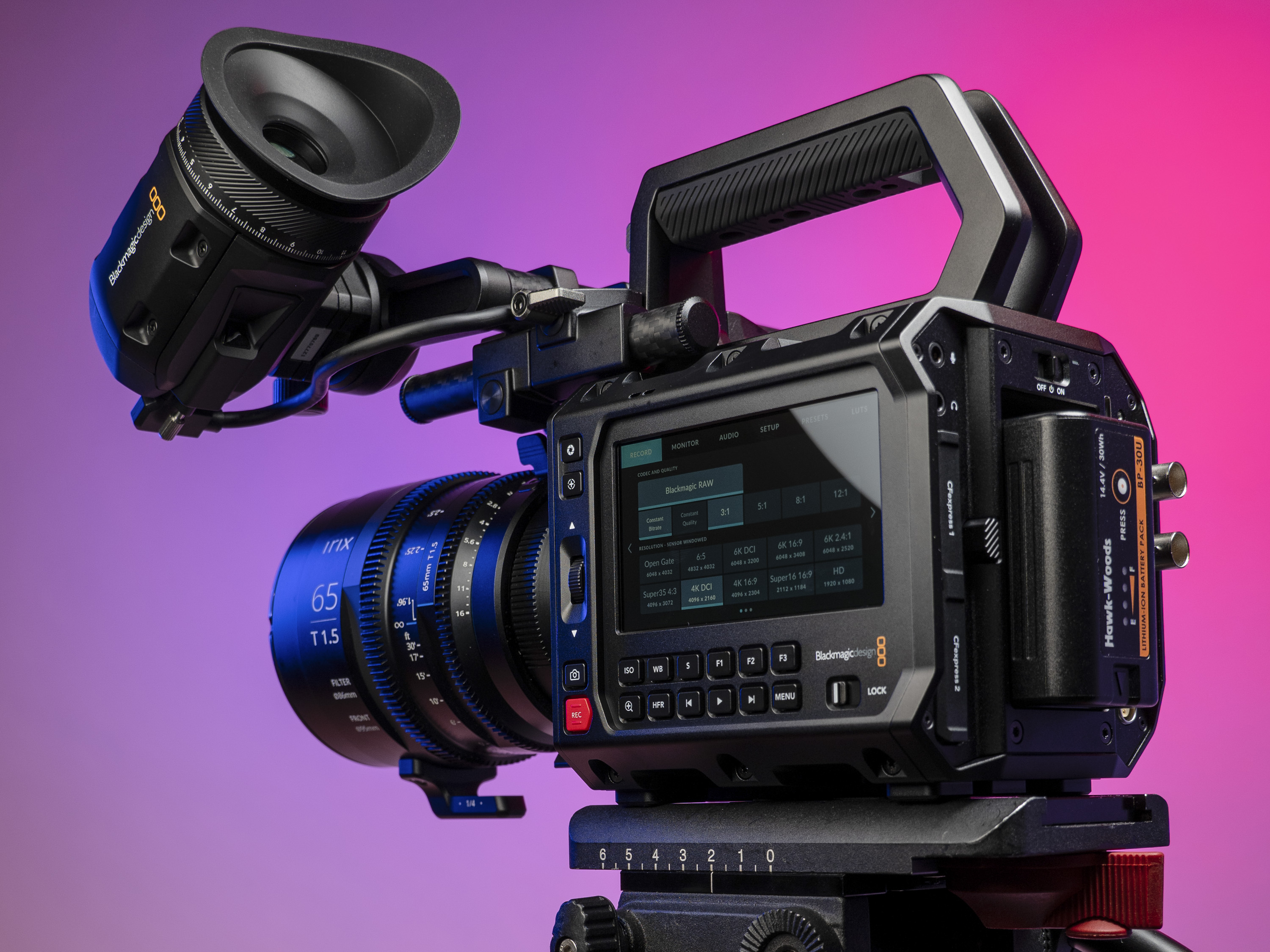 Blackmagic Pyxis 6K camera in the studio, mounted to video tripod, with a vibrant magenta background