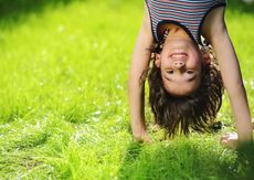 young happy boy standing on head