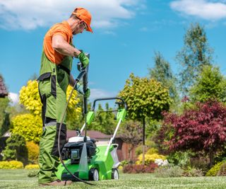 A man pressure washing a lawnmower