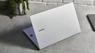 Samsung Galaxy Book Pro on wooden table with screen open and shot from behind