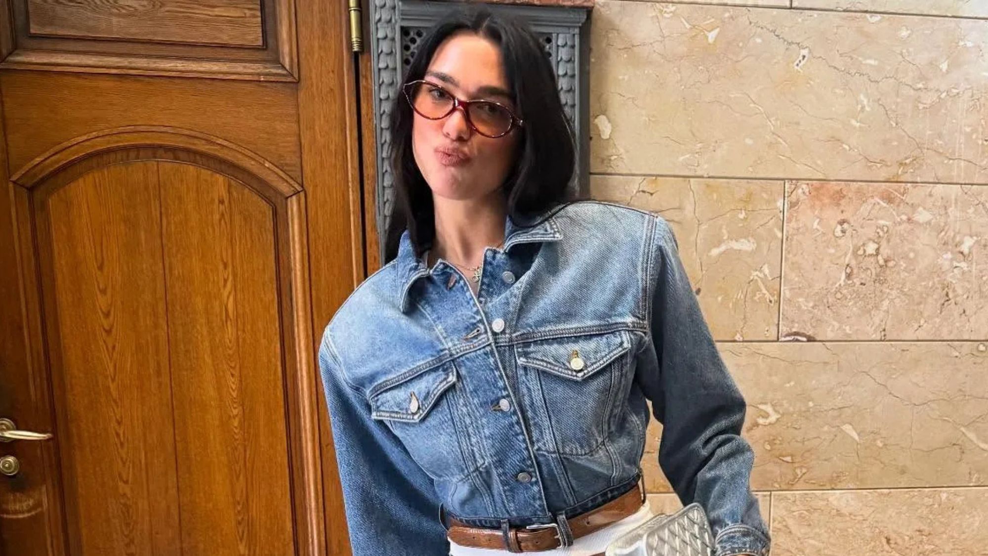 Dua Lipa wearing a denim-on-denim outfit and zebra-print heels