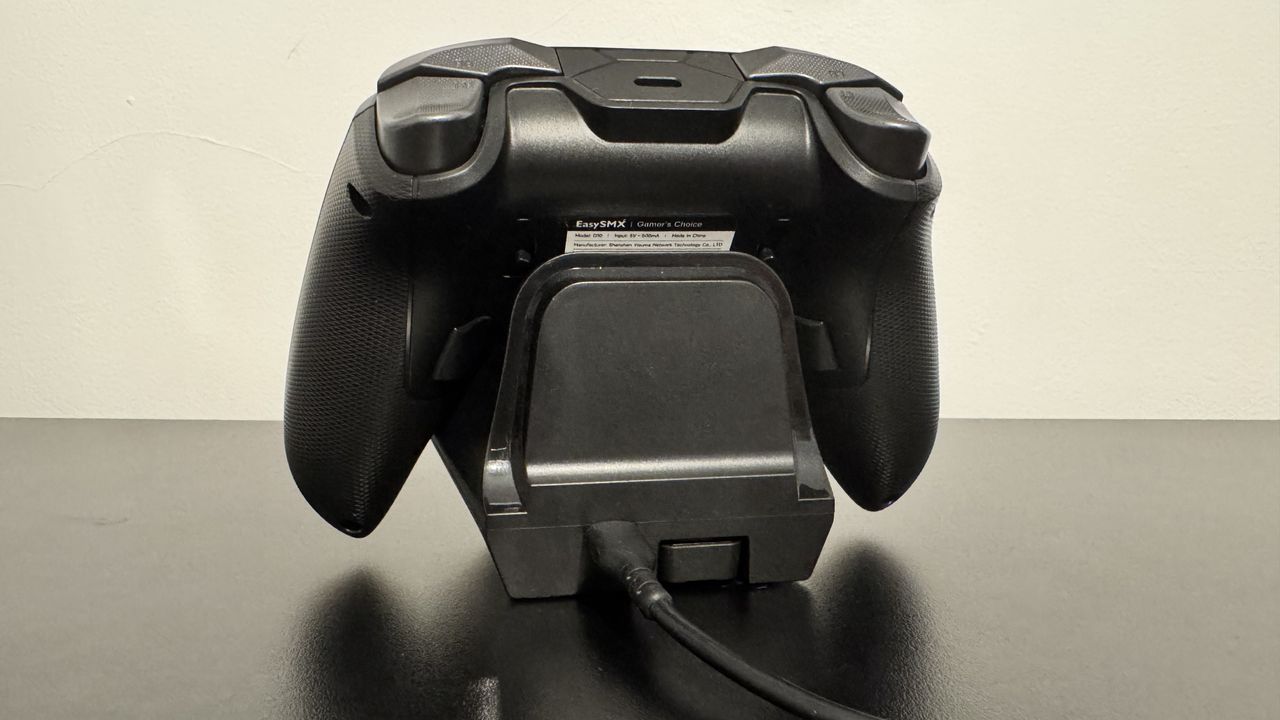 EasySMX D10 on a charging stand from the back, on a black desk