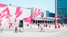 The hand-painted exterior of a fair center boasts abstract electric pink and white swathes that turn it into an open-air art installation.