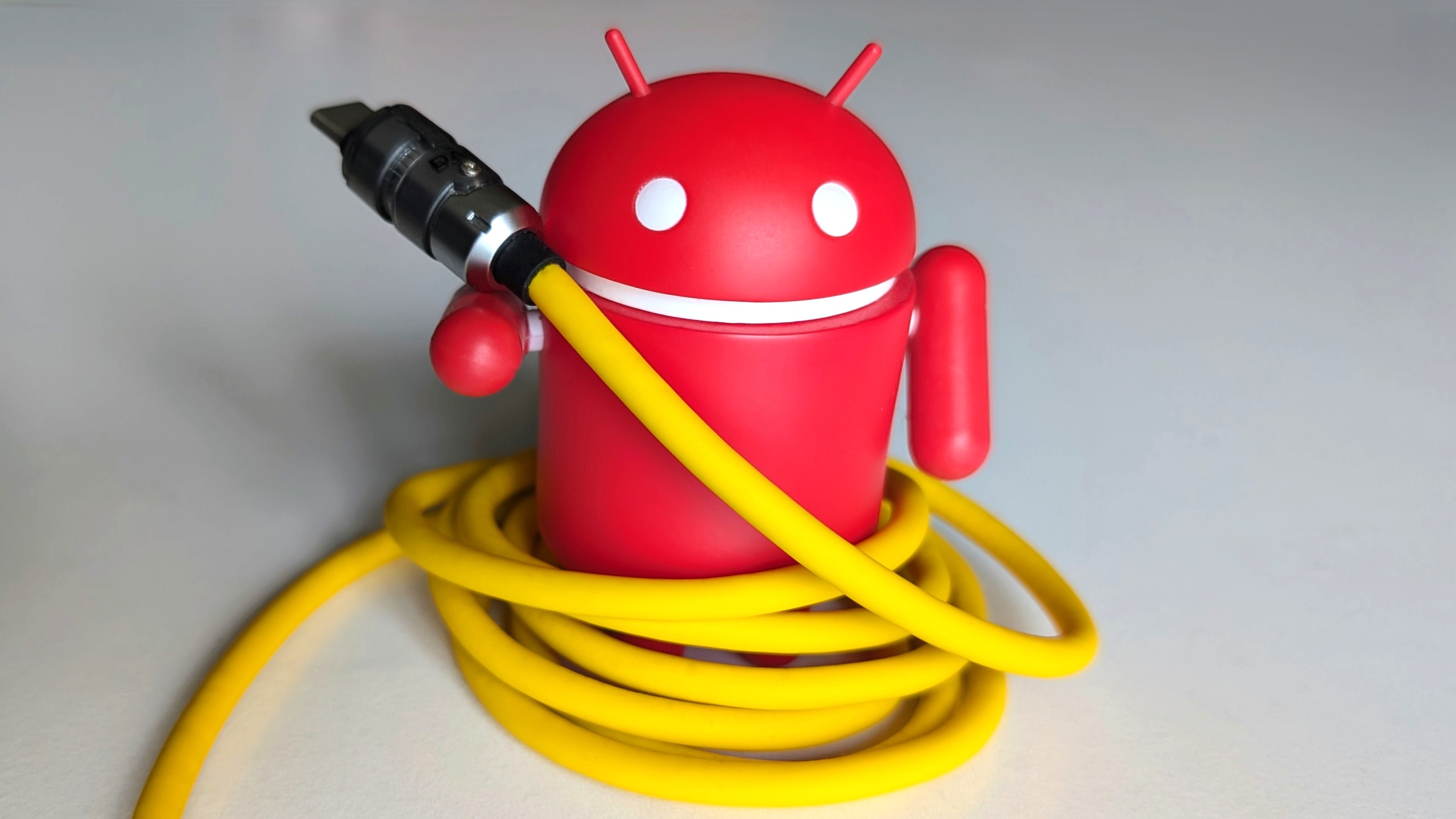 Android figurine holding a USB-C cable