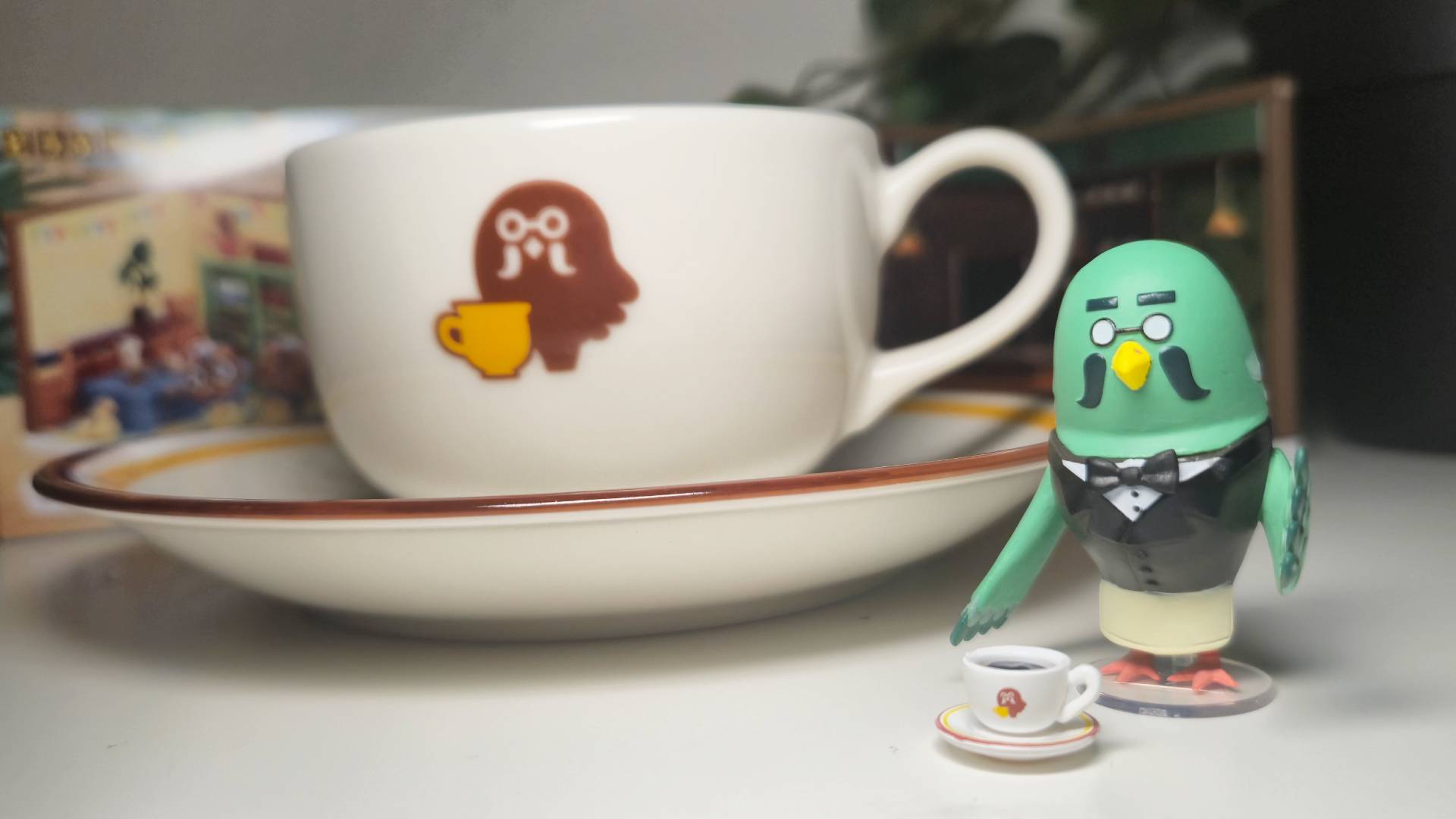 Photo of Brewster and a coffee cup toy sitting in front of a real-life Brewster cup replica.