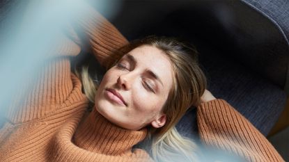 Portrait of content woman relaxing on the couch - stock photo