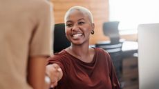 Young, happy businesswoman shaking hands in an office 