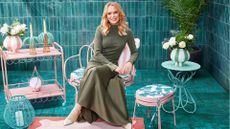 Amanda Holden in a blue tiled space surrounded by her new garden furniture range for QVC 