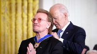 Bobo, hands clasped in prayer, receives Presidential Medal of Freedom from Joe Biden