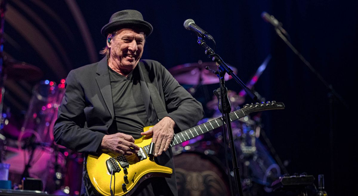 Adrian Belew wears all black and works some slide magic on his gold Parker Fly, onstage with the Beat tour