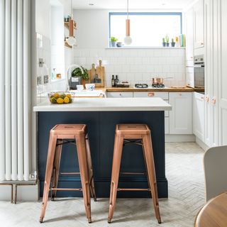 White kitchen with herringbone floor, u shaped kitchen and breakfast bar