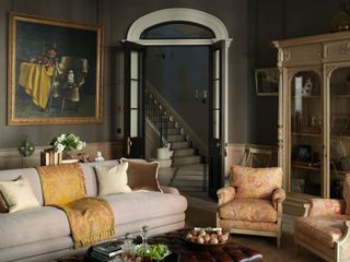 Traditional sitting room with textured yellow and orange upholstery, blankets and painting