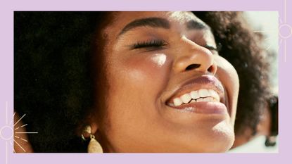 A woman smiling facing the sun to illustrate how to reapply sunscreen over makeup 
