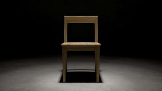 A wooden chair in a dark room. 