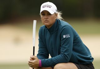 Nordqvist looks on with a green jumper and white hat