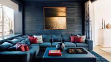 living room with dark gray walls and blue sectional