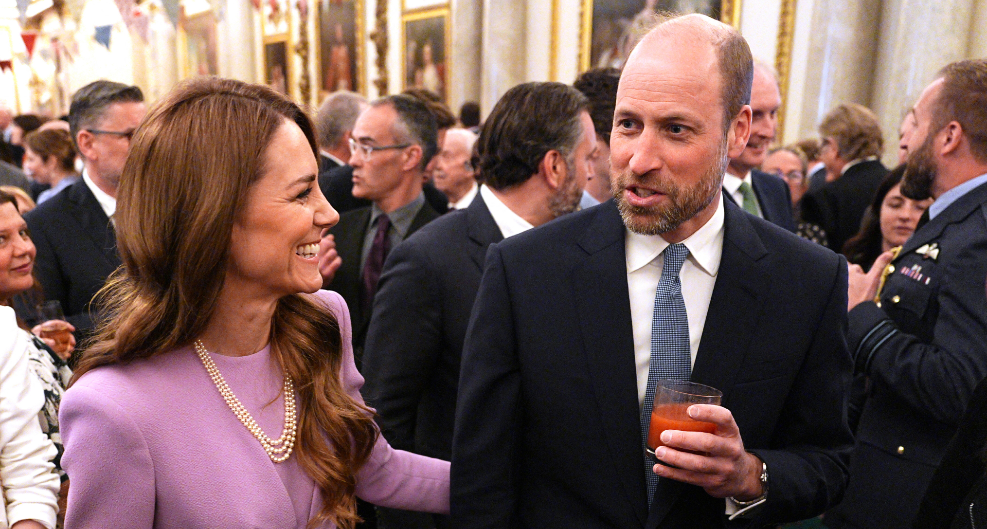 Prince William and Princess Kate laughing at a palace reception 