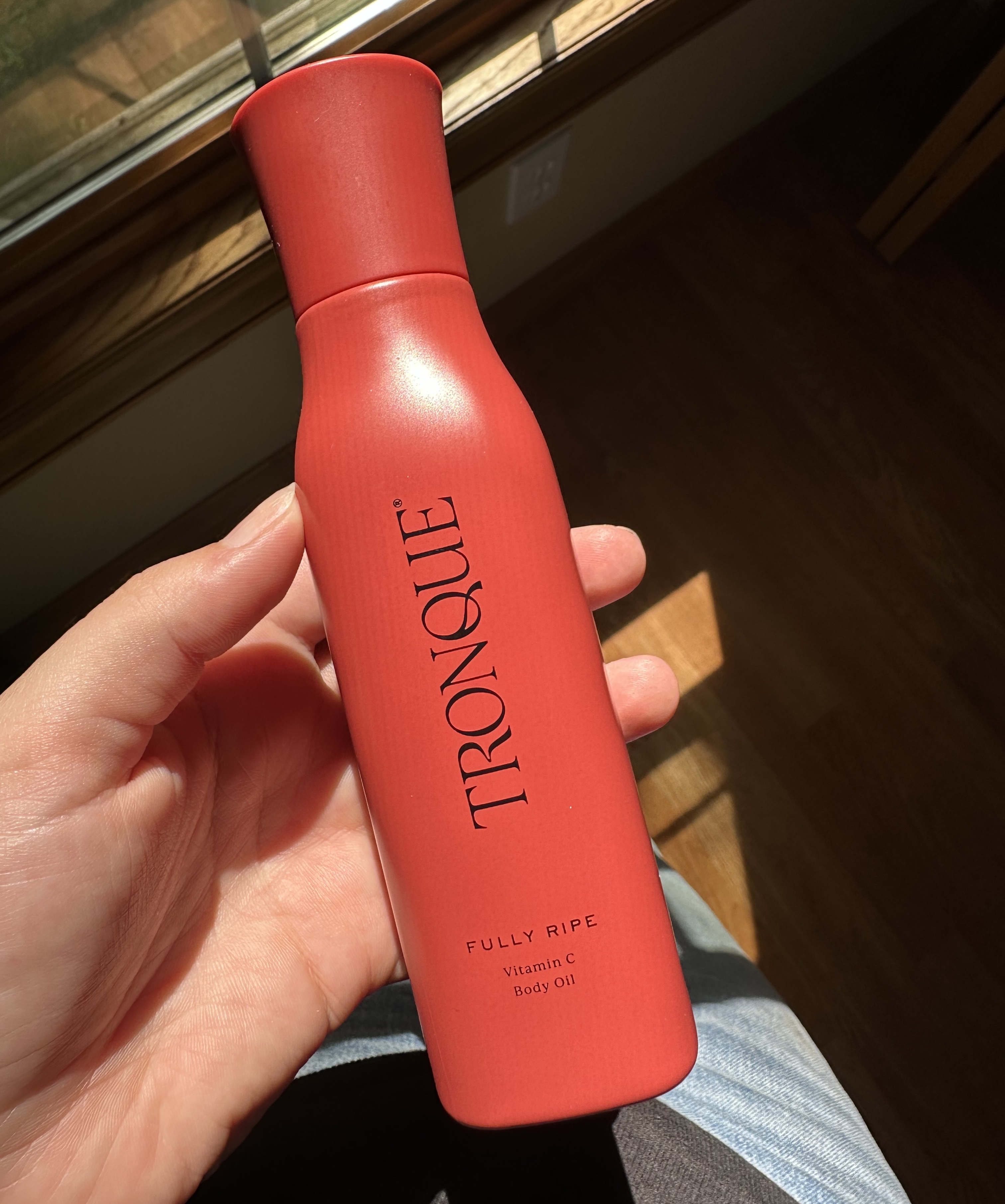Beauty editor Kaitlyn McLintock holding Tronque Fully Ripe Vitamin C Body Oil.