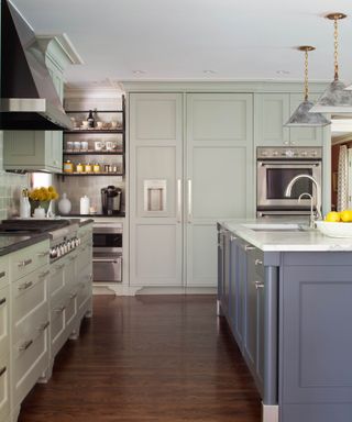 kitchen with light green cabinets and gray island