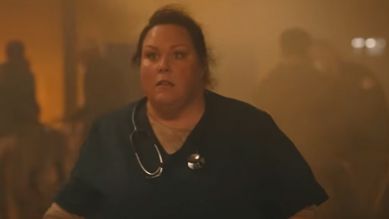 Chrissy Metz in medical scrubs looking shocked.