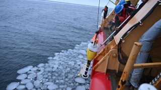 U.S. Coast Guard Cutter Healy crewmembers retrieve an instrument from water in the Chukchi Sea.