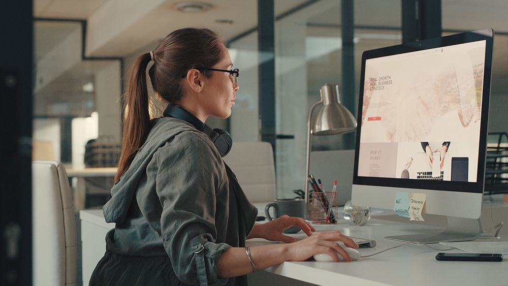 A graphic designer working at a computer screen