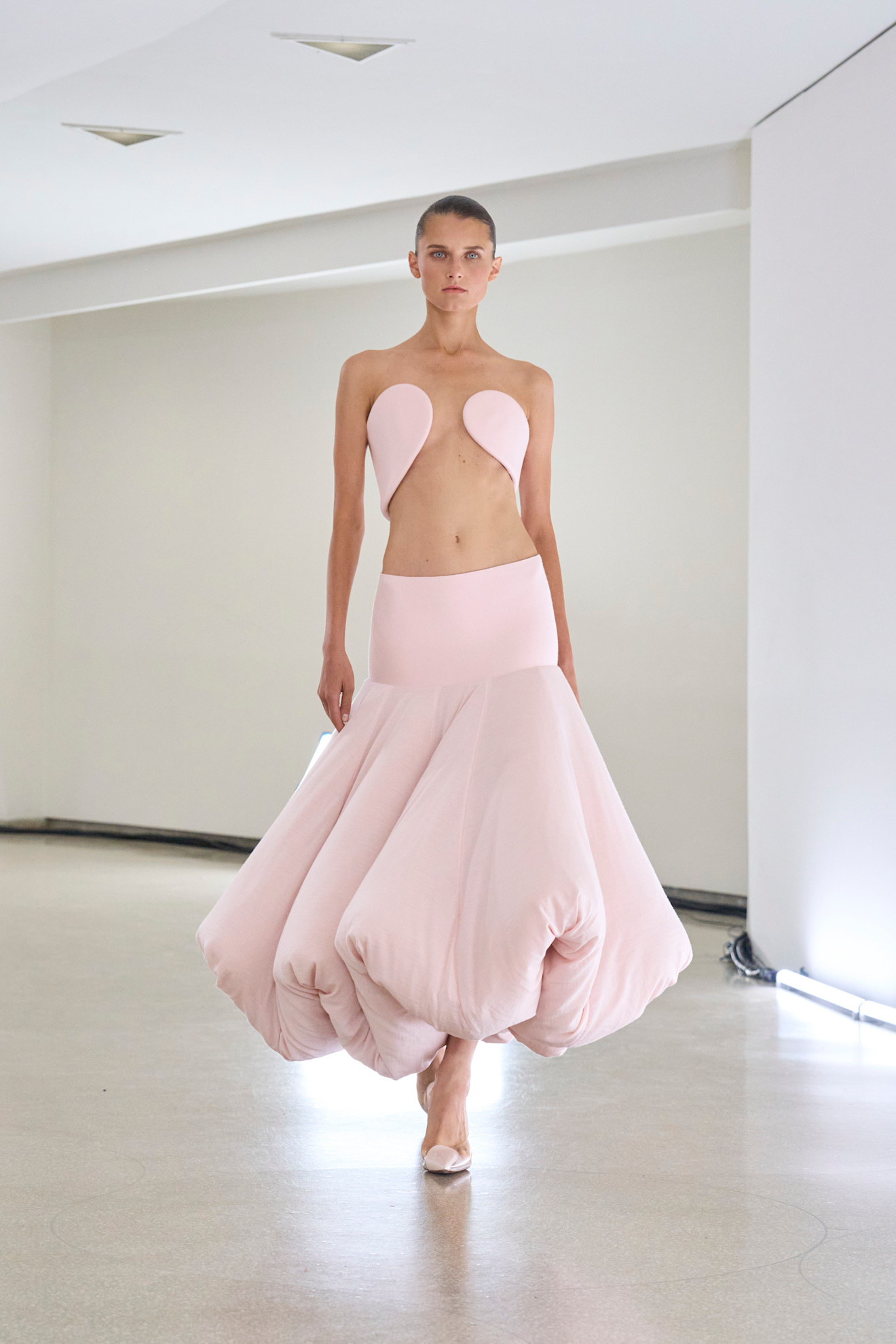 Pastel Fashion Colour Trends: A model wears a powder pink skirt and bra top on the Alaïa spring/summer 2025 runway
