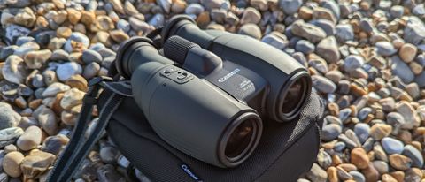 Canon 10x32 IS binoculars on a carry bag on a beach