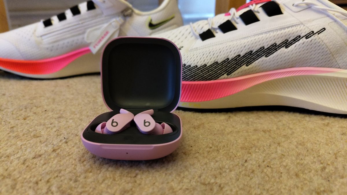 Beats Fit Pro in front of a pair of trainers