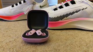 Beats Fit Pro in front of a pair of trainers