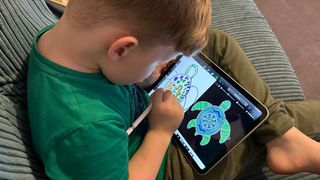 Boy using Apple Pencil to draw on iPad 2022
