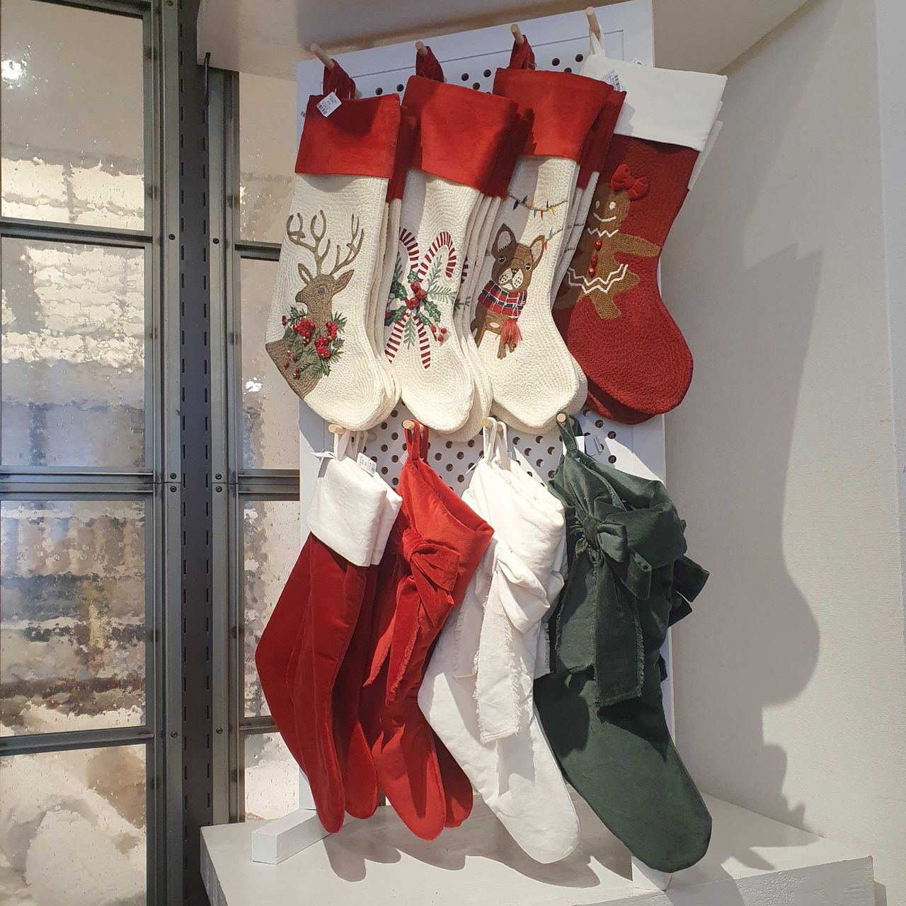 Several designs of Pottery Barn Christmas stockings displayed in its London store