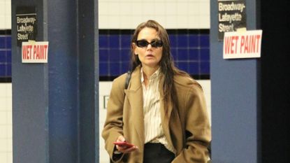 Katie Holmes wearing a camel coat and a black tote bag