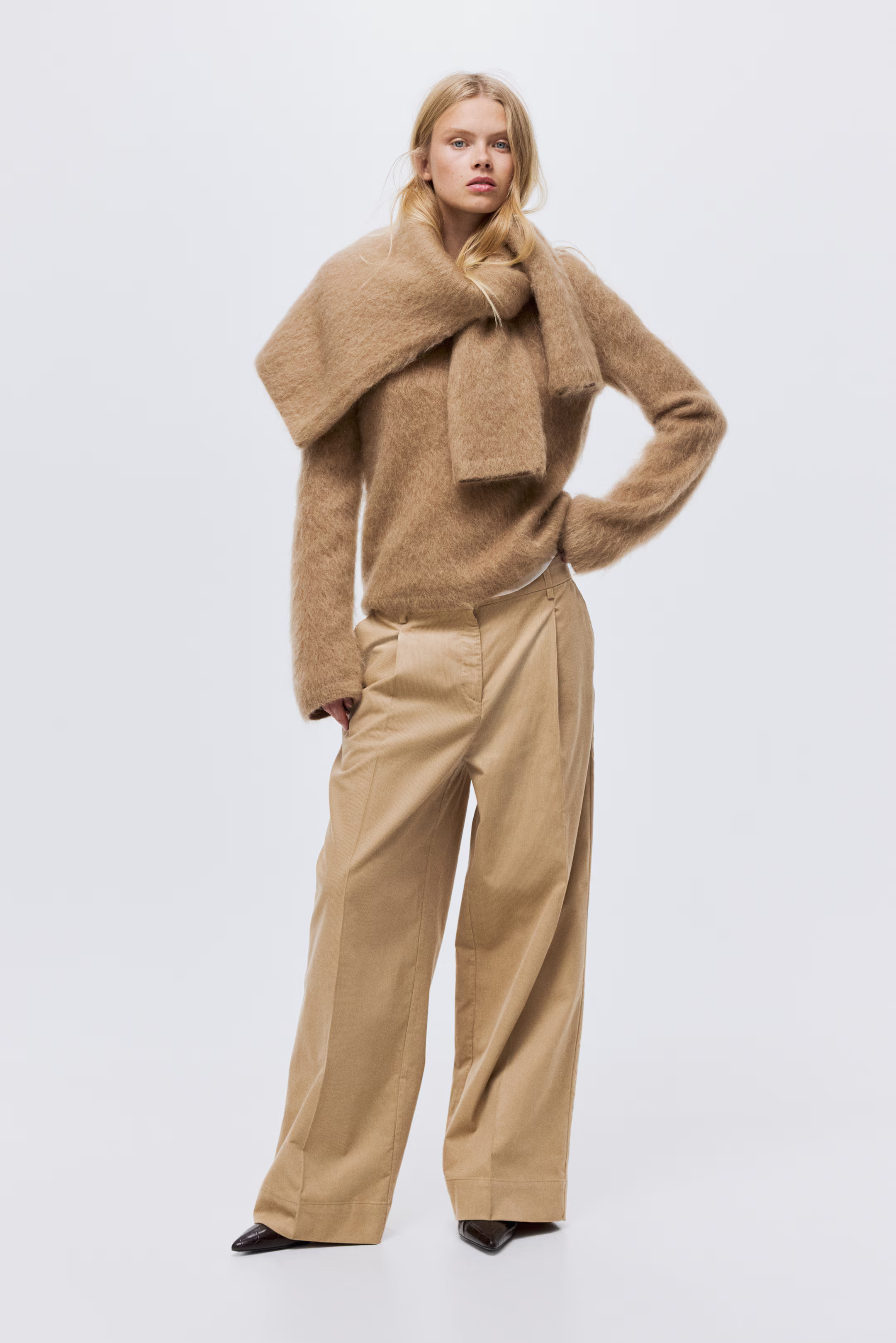 A woman wearing camel corduroy trousers and a camel jumper.