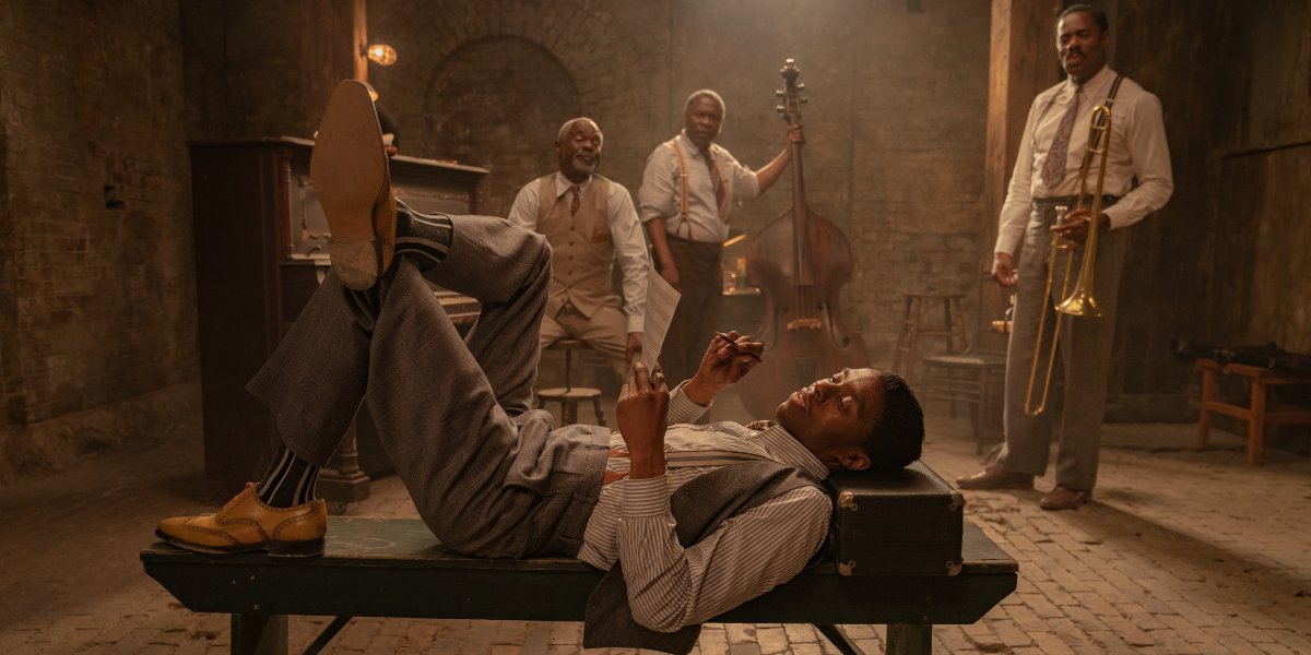 Chadwick Boseman lying on a bench in front of his band mates in Ma Rainey&#039;s Black Bottom.