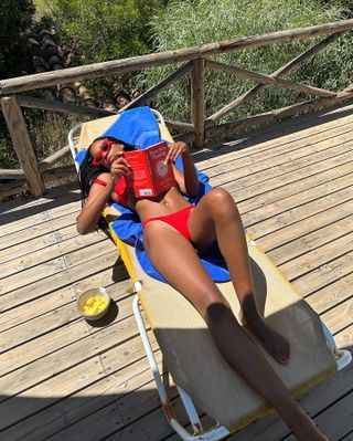 Chrissy Rutherford reading a book and wearing a bikini in Spain.