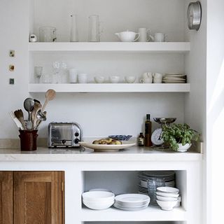 kitchen room with white shelves on wall