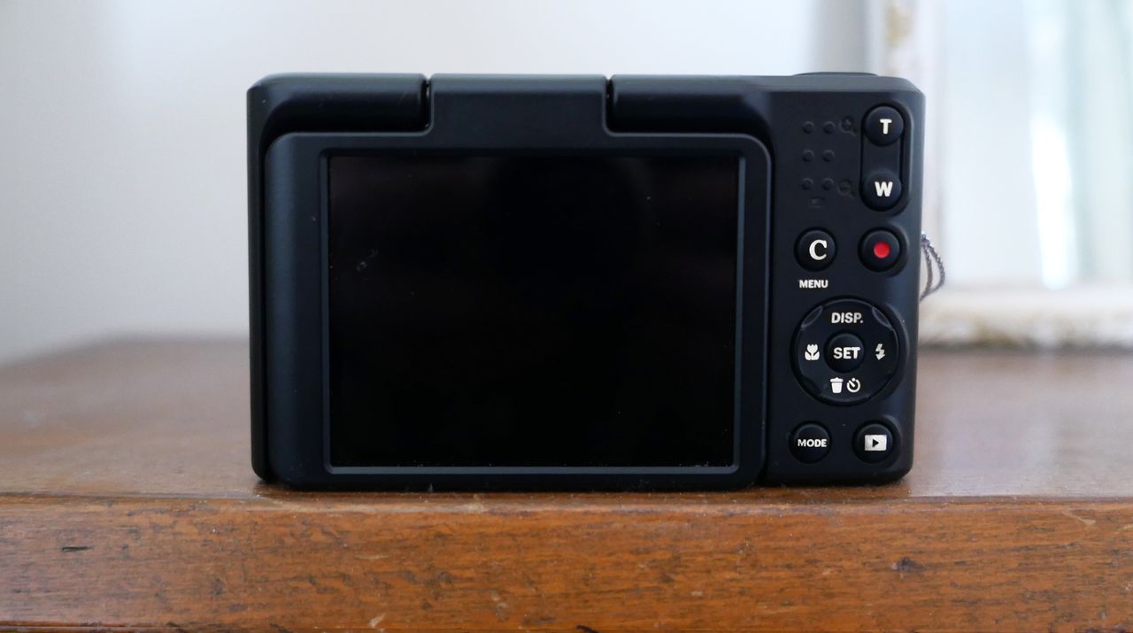 The Kodak Pixpro C1's digital camera's back panel featuring buttons and a blank display screen on a wooden surface