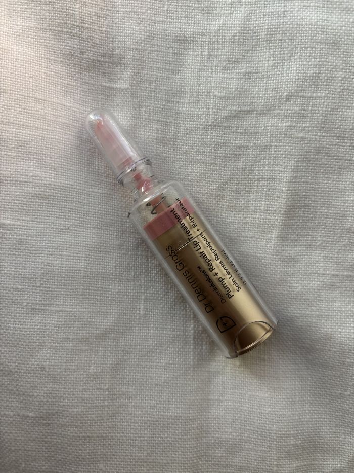 The Dr. Dennis Gross DermInfusions Lip Tint on a white linen background
