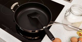Best induction pans black frying pan on an induction hob with eggs ready to fry