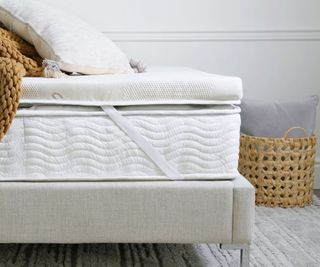 A Saatva Graphite Mattress Topper on a Saatva mattress in a modern bedroom