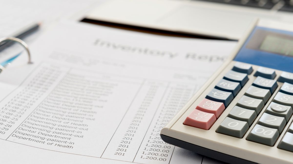 A pair of glasses and a calculator placed on a pile of forms